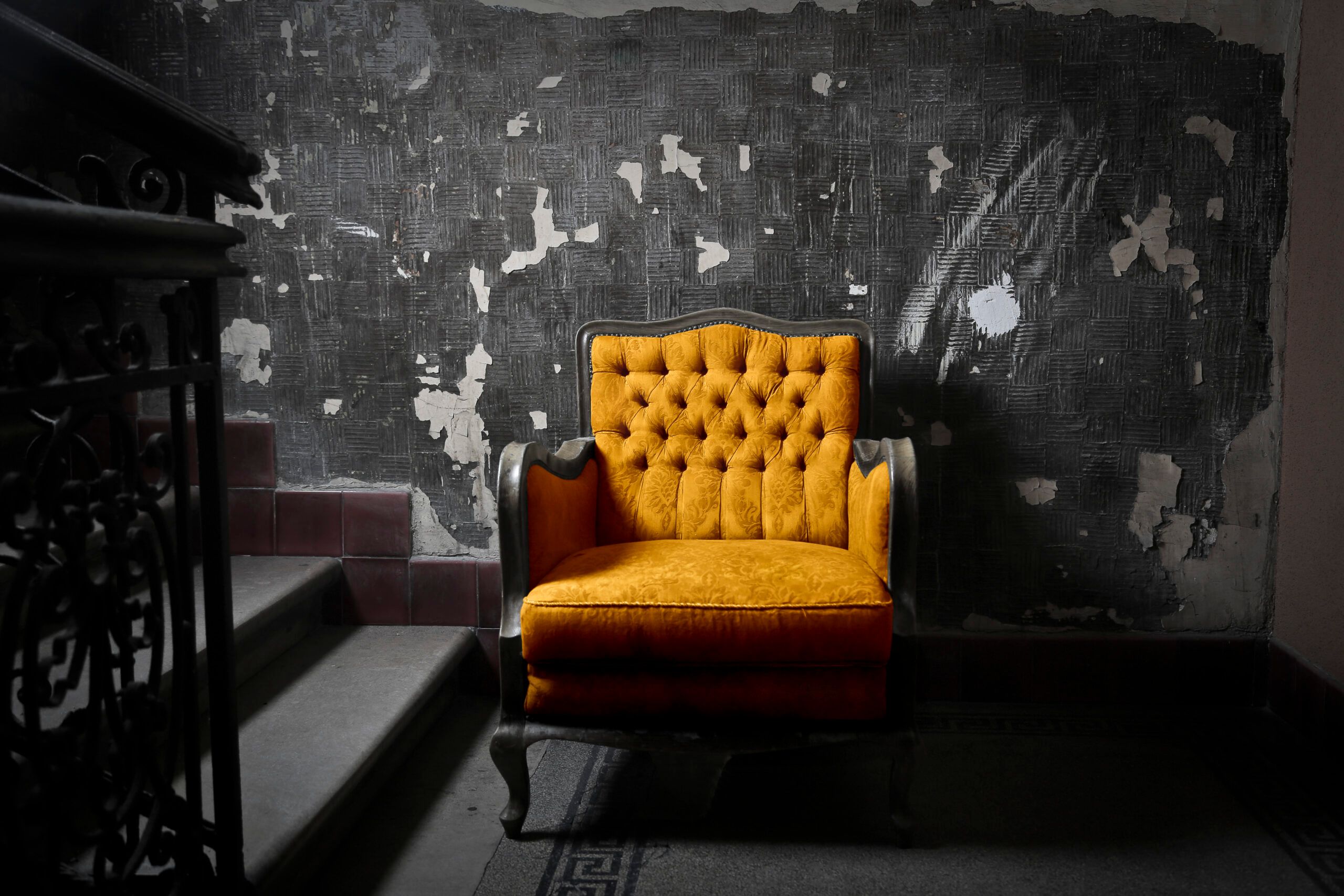 Alter gelber Sessel in altem Treppenhaus