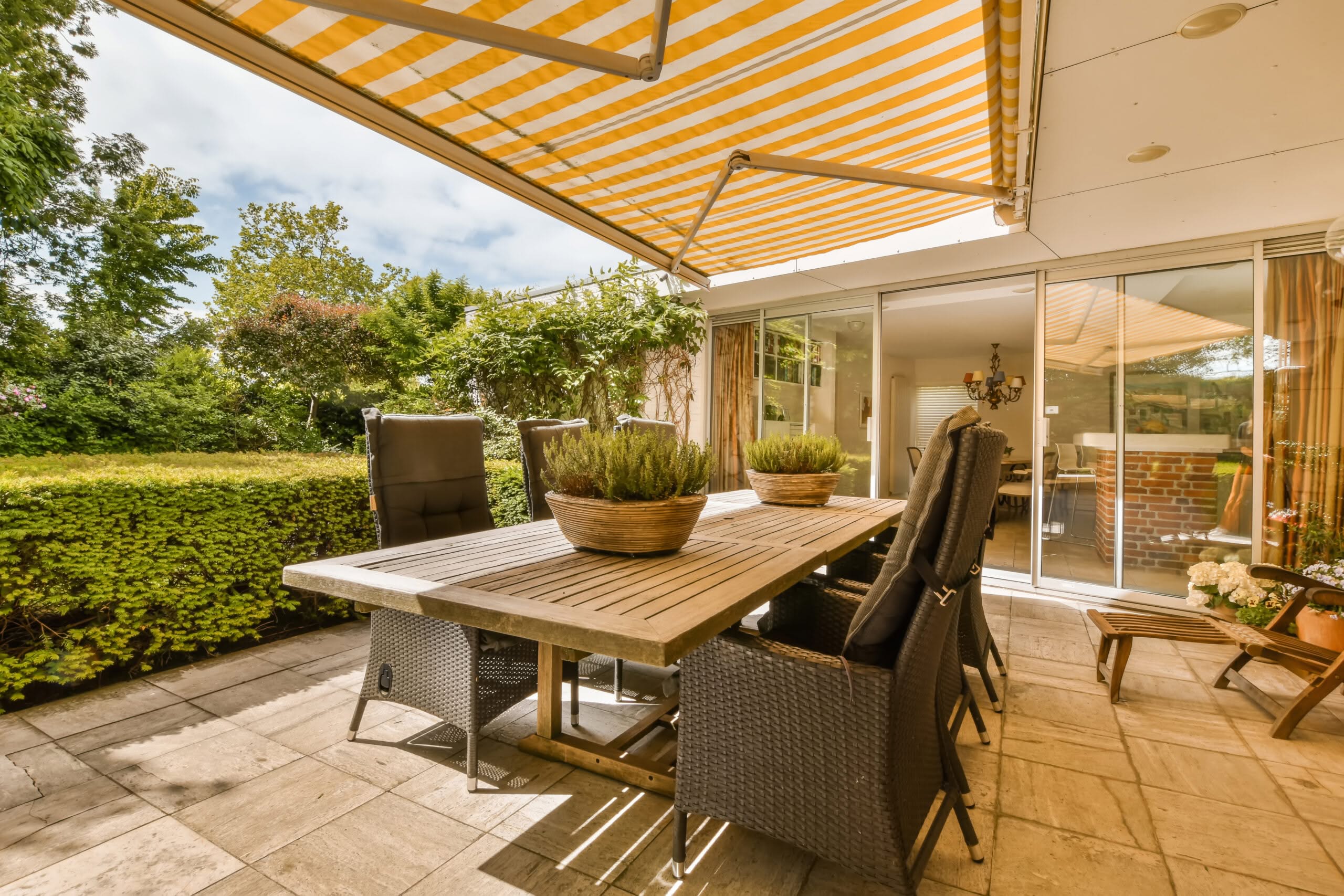 Terrasse mit Tisch und Stühlen unter Markise